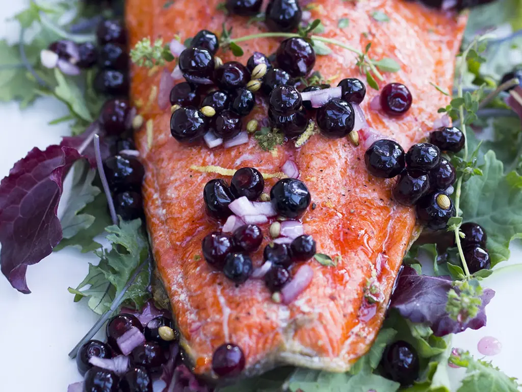 How to Grow Huckleberry Shrubs – Tart Berries You Can Eat in Late Summer 5 Cooked salmon topped with fresh huckleberries, red onions, and herbs on a bed of leafy greens.